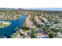 Stunning aerial view of waterfront homes, lush landscaping, and resort-style amenities in a desirable lakeside community at 10063 E Cinnabar Ave, Scottsdale, AZ 85258