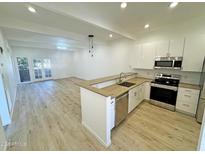 Modern kitchen with stainless steel appliances and light wood flooring at 1217 N Miller Rd # 8, Scottsdale, AZ 85257