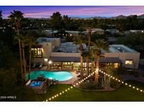 Night time aerial view of a home with a pool, spa, and beautifully landscaped yard at 6501 E Cholla St, Scottsdale, AZ 85254