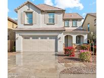 Two-story house with beige exterior, three-car garage, and landscaping at 7309 N 89Th Dr, Glendale, AZ 85305