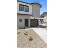 Modern two-story home featuring a light gray exterior, dark trim, and a gravel yard at 7450 S 75Th Dr, Laveen, AZ 85339