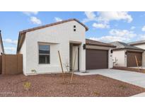 Charming single-story home showcasing stucco exterior, brown tile roof, and a two-car garage at 23411 W Albeniz Pl, Buckeye, AZ 85326