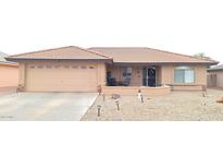 One-story house with tan colored exterior, landscaped yard, and a two-car garage at 7829 E Naranja Ave, Mesa, AZ 85209