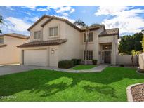 Two-story house with a large front yard, driveway, and attached garage at 1041 W Chilton Ave, Gilbert, AZ 85233