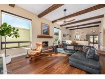 Inviting living room featuring a fireplace, wood beams, large windows and comfortable seating at 629 E Myrtle Ave, Phoenix, AZ 85020