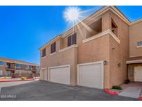 A two-story townhome with a two-car garage in a community, painted in neutral colors with balconies at 1335 E June St # 239, Mesa, AZ 85203