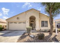 Inviting single-story home featuring a well-manicured front yard and an attached two-car garage at 17317 N Ponca Way, Surprise, AZ 85374