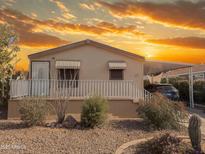 Charming single-story home with desert landscaping and covered parking under a vibrant sunset sky at 201 S Greenfield Rd # 271, Mesa, AZ 85206