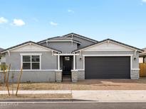 Charming single-story home with a well-manicured lawn, gray paint, and an attached two-car garage at 17703 W Southgate Ave, Goodyear, AZ 85338