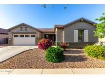 Charming single-story home featuring a well-manicured lawn, lovely desert landscaping, and a two-car garage at 20856 E Arroyo Verde Dr, Queen Creek, AZ 85142