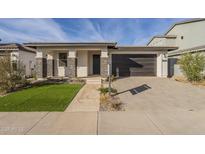 Single-story home with a two-car garage and landscaped lawn at 12028 N Luckenbach St, Surprise, AZ 85388