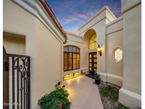 Elegant home exterior at dusk, featuring a walkway, landscaping, and architectural details at 13503 E Charter Oak Dr, Scottsdale, AZ 85259