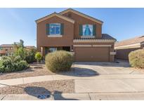 Two-story house with a tan exterior, two-car garage, and landscaping at 306 N 21St Cir, Coolidge, AZ 85128