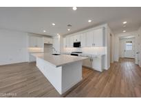 Well-lit kitchen featuring a spacious island and modern white cabinetry at 17316 W Via Dona Rd, Surprise, AZ 85387
