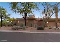 Desert landscape surrounds this single-story home with a neutral facade at 7479 E Sunset Sky Cir, Scottsdale, AZ 85266