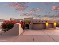 Stunning home exterior with a two car garage, mature landscaping, and a beautiful desert sunset at 15155 E Westridge Dr, Fountain Hills, AZ 85268