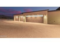 Three-car garage with modern wood-like doors and exterior lighting at 40564 N 50Th St, Cave Creek, AZ 85331