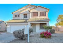 Two-story house with a white exterior, landscaping, and a two-car garage at 10350 W Alvarado Rd, Avondale, AZ 85392