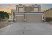 Two-story house with tan exterior, two-car garage, and landscaping at 9131 W Albert Ln, Peoria, AZ 85382