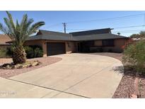 Ranch-style home with a large driveway and mature landscaping at 3325 W Belmont Ave, Phoenix, AZ 85051