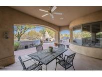 Comfortable covered outdoor patio with ceiling fan, fireplace and stainless steel grill at 37615 N Tranquil Trl, Carefree, AZ 85377