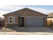 Charming single-story home with a two-car garage, stone accents and desert landscaping at 8657 W Warner St, Tolleson, AZ 85353