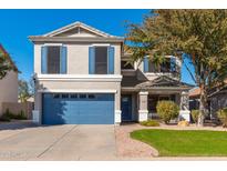 Inviting two-story home with blue accents, a well-manicured lawn, and a convenient two-car garage at 4660 E Torrey Pines Ln, Chandler, AZ 85249