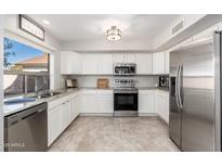 Bright kitchen featuring stainless steel appliances, granite countertops, and white cabinetry, ideal for cooking at 4660 E Torrey Pines Ln, Chandler, AZ 85249