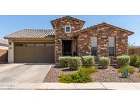 One-story home with stone exterior, two-car garage, and landscaping at 2837 W Minton St, Phoenix, AZ 85041