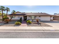 Single-story home with landscaped yard and two-car garage at 12715 W Beechwood Dr, Sun City West, AZ 85375