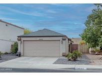 House exterior featuring a two-car garage and well-maintained landscaping at 24648 N 40Th Ln, Glendale, AZ 85310