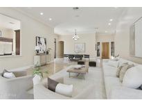 Open concept living and dining area with travertine floors, neutral decor, and a light wood front door at 8146 E Wingspan Way, Scottsdale, AZ 85255