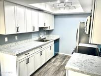 Updated kitchen with white cabinets, granite counters, and stainless steel appliances at 1230 N 84Th Pl, Scottsdale, AZ 85257