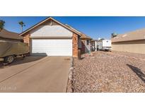 Brick home with a white garage door and gravel landscaping at 4110 E La Puente Ave, Phoenix, AZ 85044