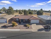 Single story home with tile roof, two-car garage, and landscaped yard at 4047 E Catalina Cir, Mesa, AZ 85206