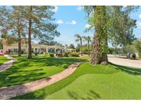 Expansive backyard featuring a brick path and mature trees at 7214 E Royal Palm Rd, Scottsdale, AZ 85258