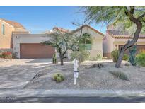 Single-story home with desert landscaping and two-car garage at 23635 N 75Th Pl, Scottsdale, AZ 85255