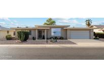 Tan mid-century modern home with carport and small front yard at 10515 W Oak Ridge Dr, Sun City, AZ 85351