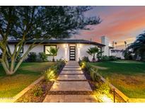 Charming home exterior with walkway, manicured lawn, modern door, and warm landscape lighting at 1345 W Edgemont Ave, Phoenix, AZ 85007