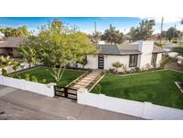 Charming home featuring a black privacy gate, manicured lawn and white painted brick perimeter at 1345 W Edgemont Ave, Phoenix, AZ 85007