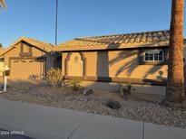 Single-story home with tile roof,desert landscaping, and a two-car garage at 14426 W Morning Star Trl, Surprise, AZ 85374