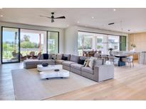 Spacious living room with a large sectional sofa and seamless flow to the kitchen and outdoor areas at 6215 N Casa Blanca Dr, Paradise Valley, AZ 85253