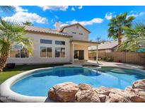 Backyard featuring a sparkling pool, patio area and manicured lawn with lush palms; ideal for outdoor entertaining at 19406 N 31St Way, Phoenix, AZ 85050