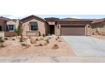 Charming single-story home featuring a stone facade and a two-car garage at 7674 W Cactus Wren Way, Florence, AZ 85132