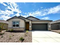 Charming single-story home with a two-car garage, neutral stucco, and stone accents against a bright, blue sky at 8391 W Mantle Way, Florence, AZ 85132