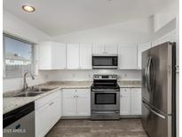 Modern kitchen featuring stainless steel appliances and white cabinetry at 10101 N 91St Ave # 139, Peoria, AZ 85345