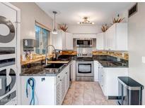Bright kitchen featuring white cabinetry, granite countertops, and stainless steel appliances at 4600 N 68Th St # 313, Scottsdale, AZ 85251