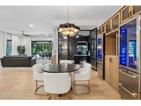 Modern dining area with a round table and white chairs, adjacent to a kitchen and living area at 5250 E Deer Valley Dr # 153, Phoenix, AZ 85054