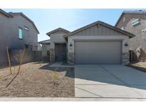 Single-story home with gray exterior, stone accents, and a two-car garage at 23227 W Florence Ave, Buckeye, AZ 85326