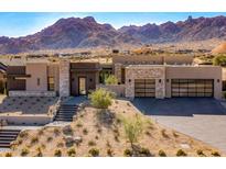 Beautiful modern home with a desert landscape and a mountain backdrop, featuring a three-car garage at 12659 E Shadow Ridge Dr, Scottsdale, AZ 85255